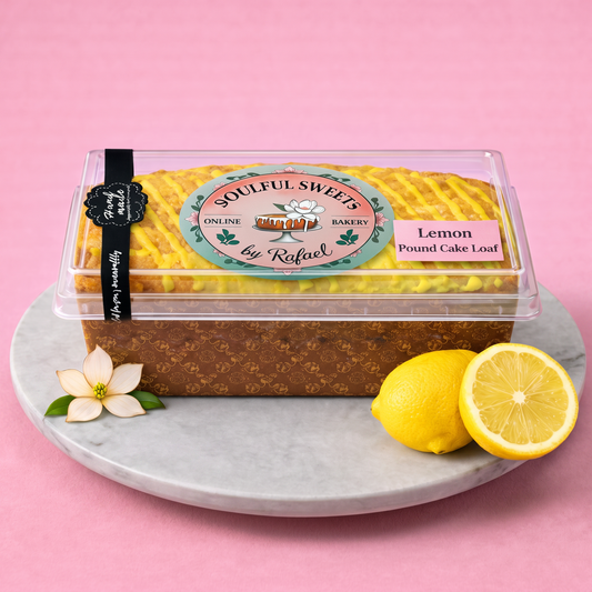 Soulful Sweets by Rafael lemon pound cake loaf in a clear container with lemon drizzle on a marble platter