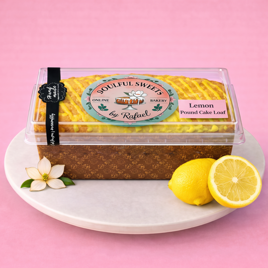 Soulful Sweets by Rafael lemon pound cake loaf with yellow drizzle in clear packaging on a white plate with lemons.