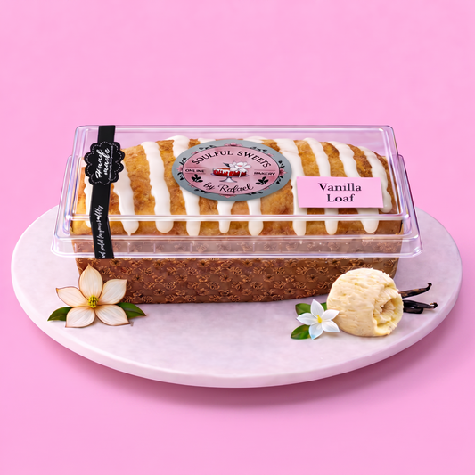 Soulful Sweets by Rafael handcrafted vanilla glazed pound cake loaf in a clear display container on a marble plate.