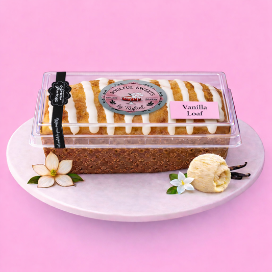 Soulful Sweets by Rafael vanilla pound cake loaf in a clear plastic container with white icing drizzle on pink plate