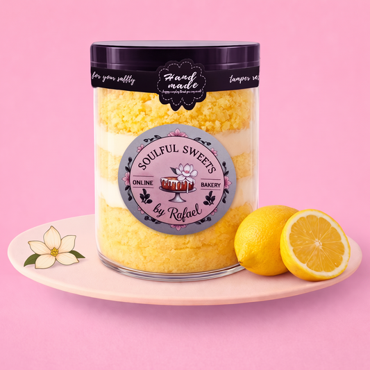 Soulful Sweets by Rafael zesty lemon cake jar with layers of moist sponge and creamy frosting on a pink plate.